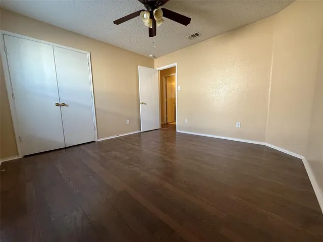 an empty room with a ceiling fan and carpet