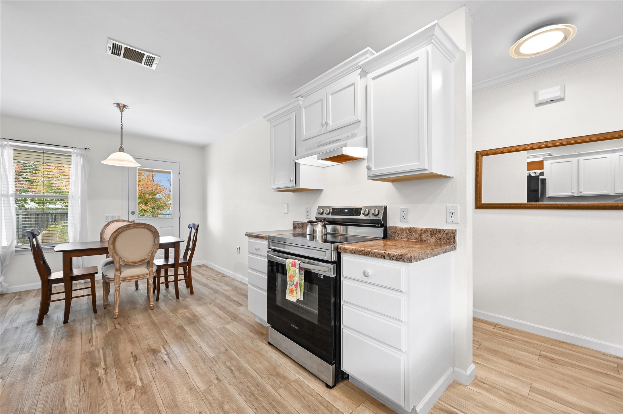 7620 Cayenne Lane Austin, TX 78741 - Photo 13 of 27 a kitchen with stainless steel appliances granite countertop a stove top oven a sink a dining table and chairs with wooden floor