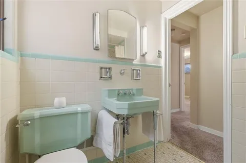 a bathroom with a toilet sink and mirror