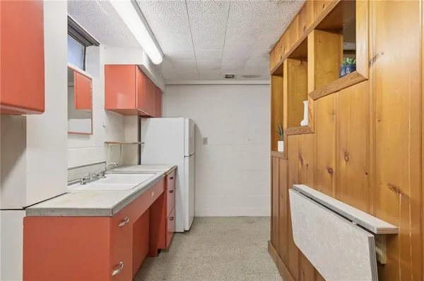 a utility room with a sink a refrigerator and a sink