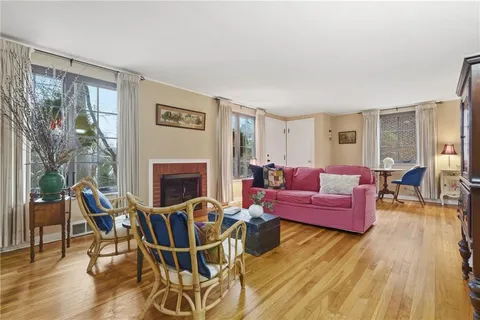 a living room with furniture a large window and a fireplace