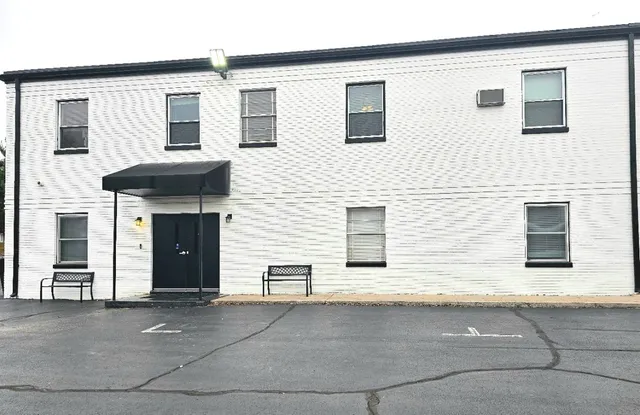 a front view of a house with a parking space