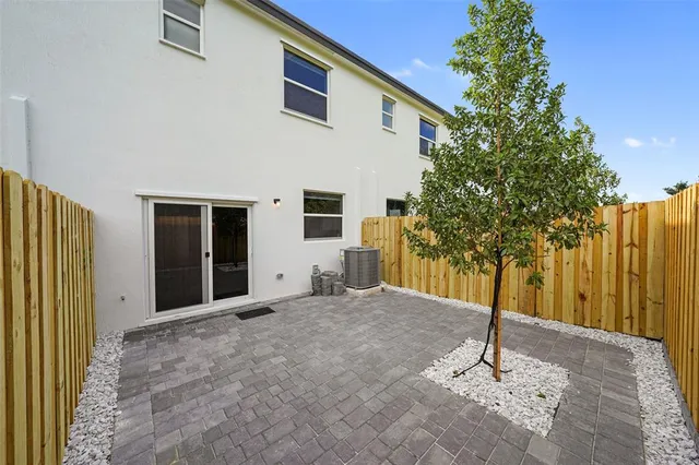 a front view of a house with a yard and potted plants