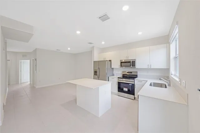 a kitchen with stainless steel appliances a refrigerator stove microwave and sink