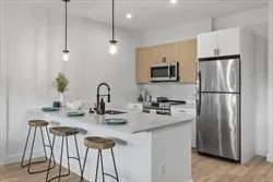 a kitchen with stainless steel appliances granite countertop a sink refrigerator and microwave