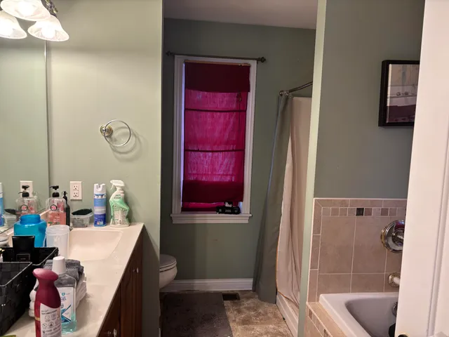 a bathroom with a bathtub shower sink and mirror