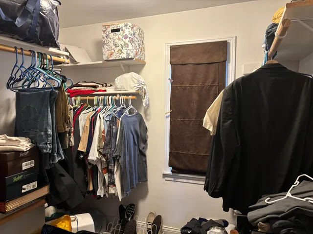 a view of walk in closet with clothes and shoes