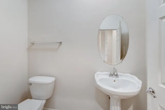 a bedroom with a bed a mirror and a large window