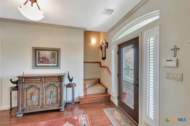 a view of a hallway with entryway wooden floor and front door
