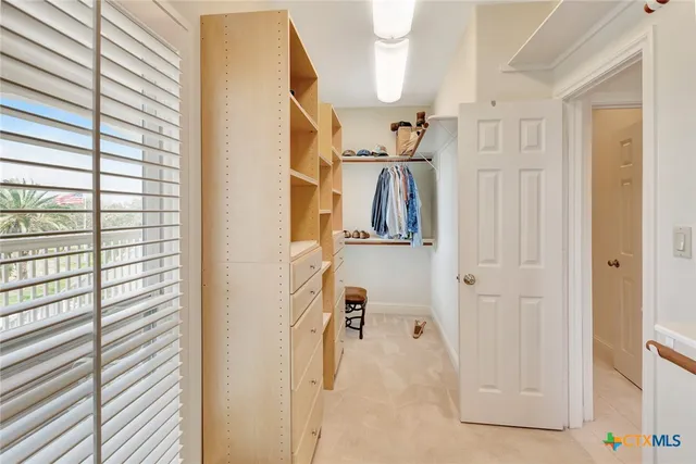 a spacious bedroom with a bed and a flat screen tv