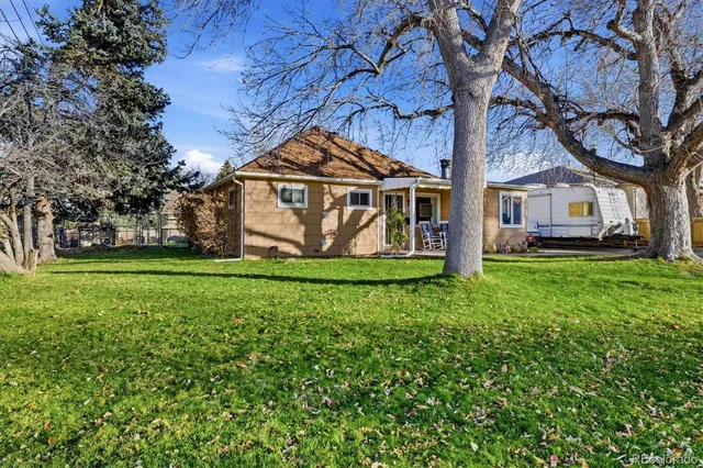 a view of a house with backyard and a tree