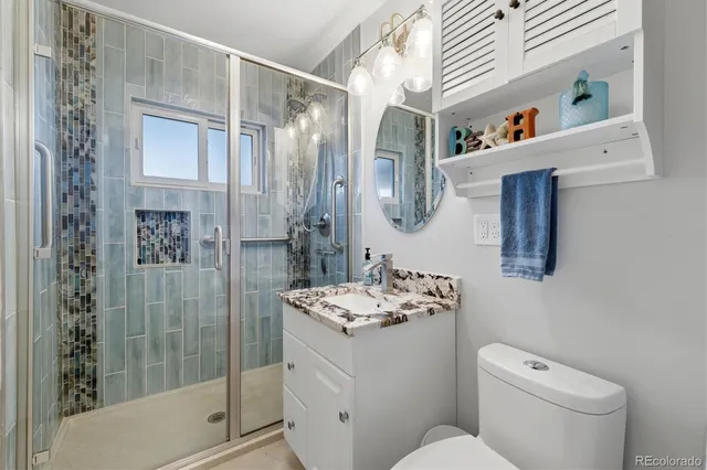 a bathroom with a sink a toilet and shower