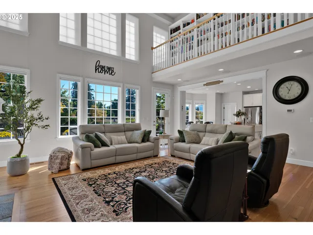 a living room with furniture a clock and a window
