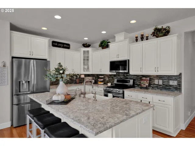 a kitchen with stainless steel appliances kitchen island granite countertop a sink and cabinets