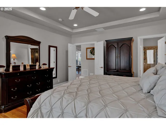 a bedroom with a bed and a large mirror on dresser