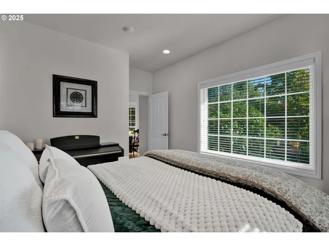 a bedroom with a bed and a large window