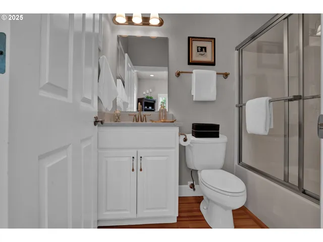a bathroom with a toilet sink a vanity and mirror