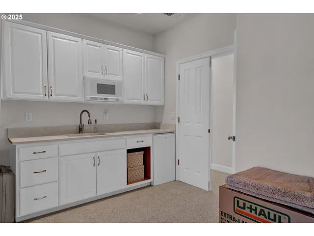 a kitchen with granite countertop white cabinets and sink