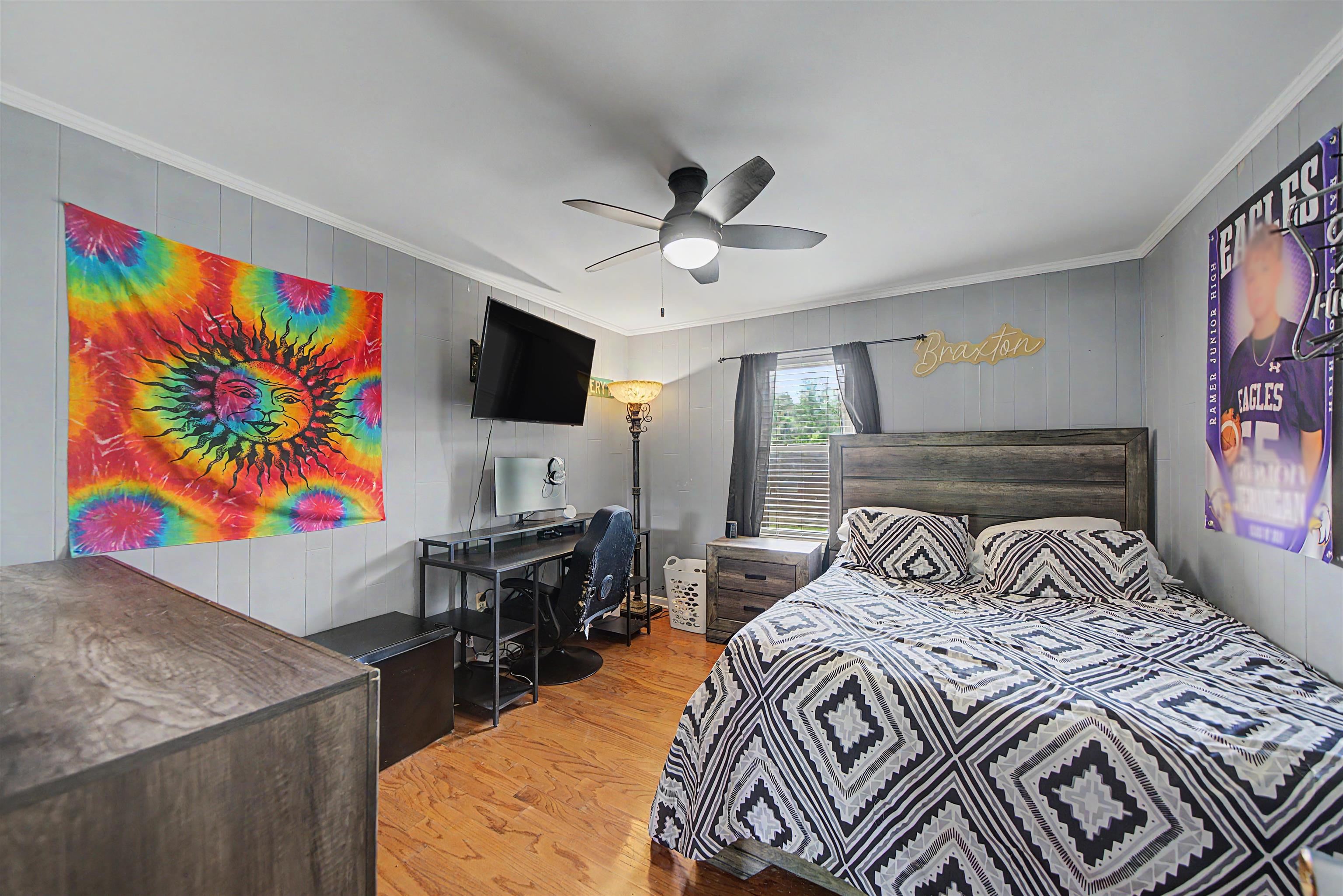 336 57th Highway West Ramer, TN 38367 - Photo 8 of 39 Spacious bedroom featuring wood-finish flooring, a ceiling fan with integrated lighting, and a window with horizontal blinds