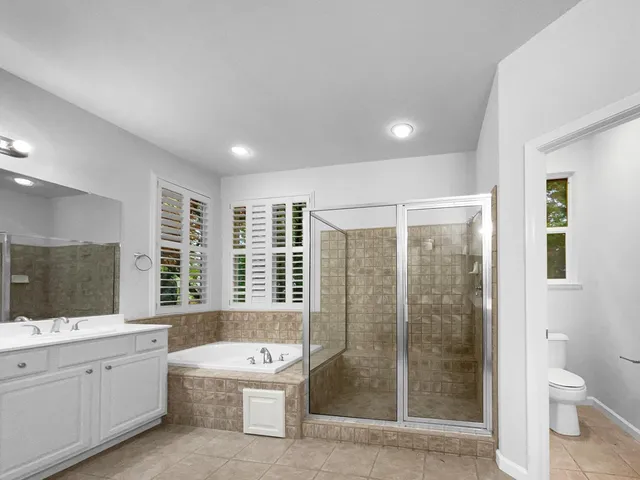 a bathroom with a double vanity sink toilet and shower