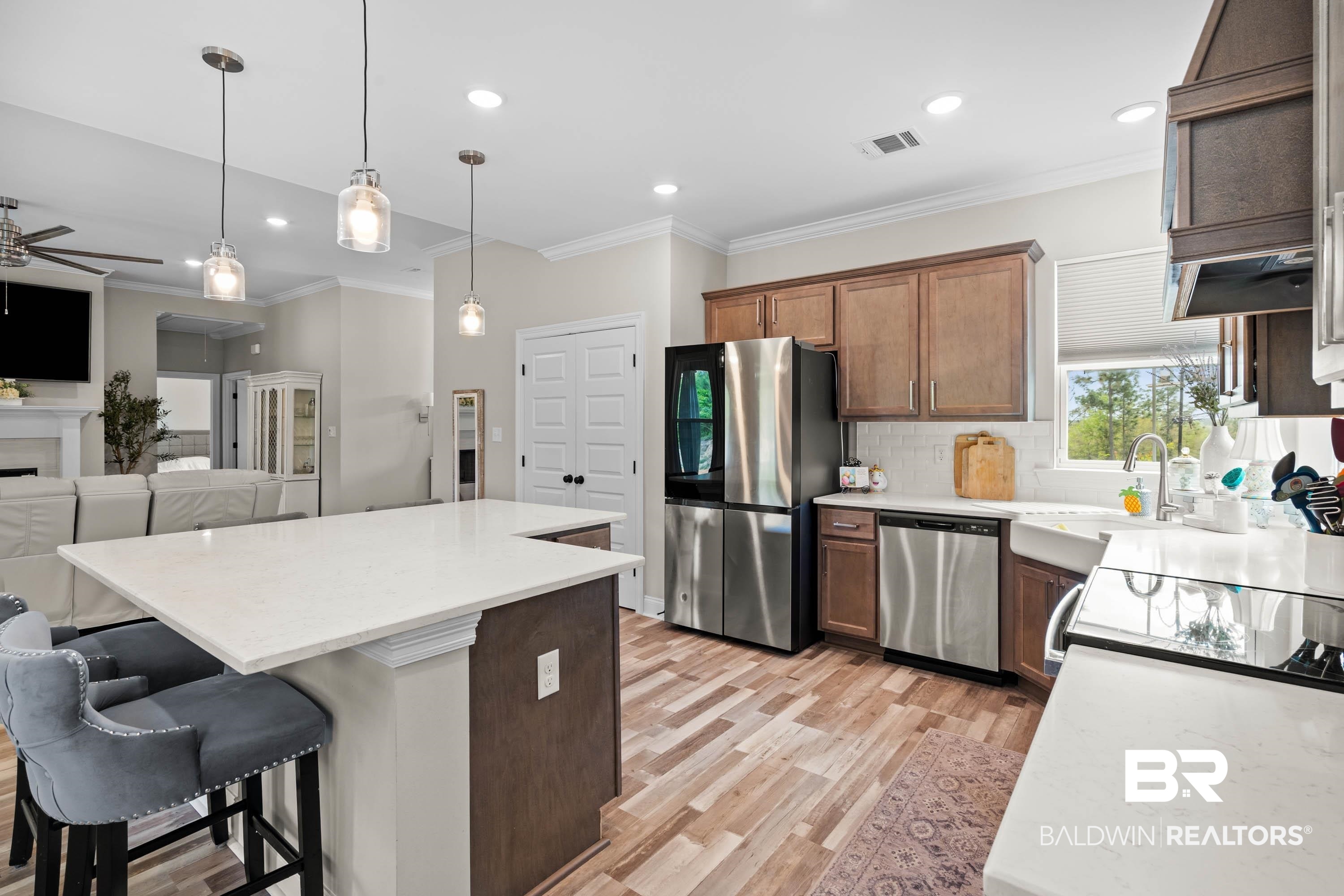 7150 Powell Road, Unit LOT 6A Eight Mile, AL 36613 - Photo 34 of 35 Kitchen featuring open floor plan, stainless steel appliances, crown molding, a ceiling fan, and a breakfast bar