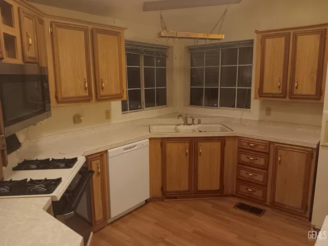 a kitchen with stainless steel appliances granite countertop a stove a sink and a microwave