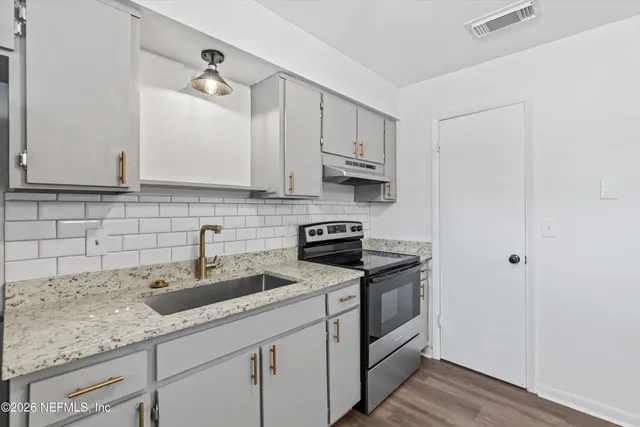 a kitchen with stainless steel appliances granite countertop a sink stove and cabinets