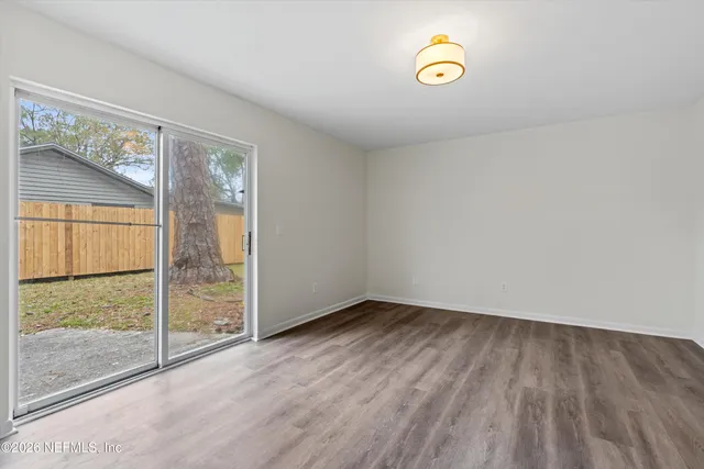 a view of a room with wooden floor and a window