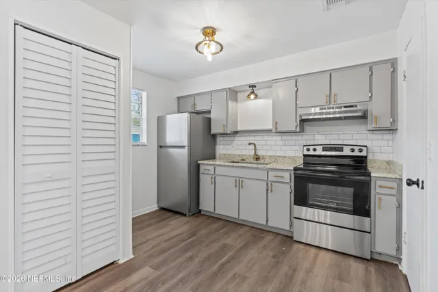 a kitchen with a refrigerator and a stove