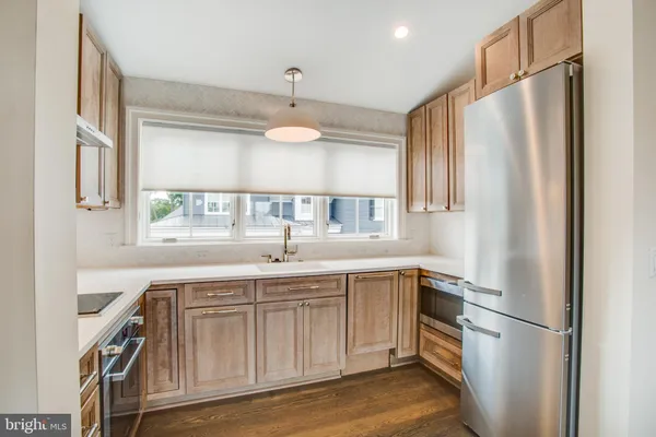 a kitchen with stainless steel appliances granite countertop a refrigerator a sink and a stove