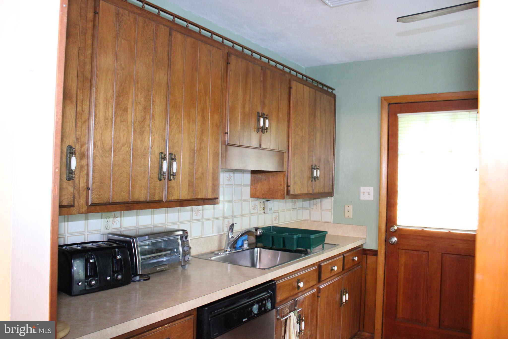 6036 Chesworth Road Baltimore, MD 21228 - Photo 7 of 15 a kitchen with appliances a sink and cabinets