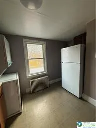 a view of room with window and refrigerator
