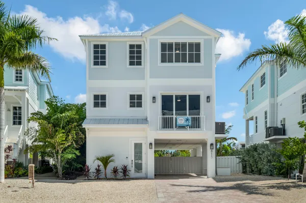 a front view of a house with a tree