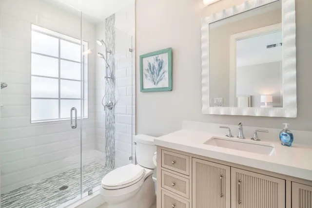 a bathroom with a granite countertop sink a toilet and a shower