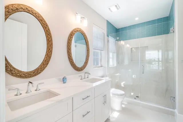 a bathroom with a double vanity sink mirror and shower