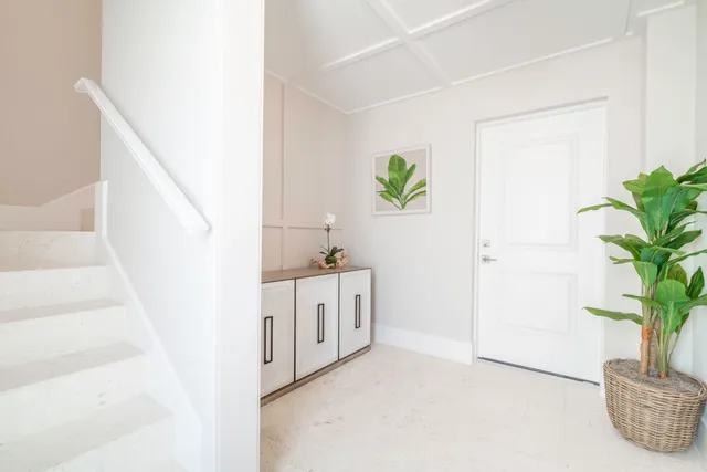 a hallway with cabinets and a potted plant