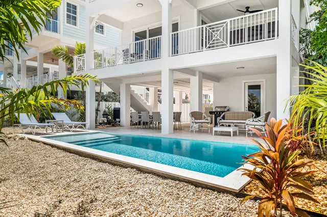 a view of a house with a swimming pool and sitting area