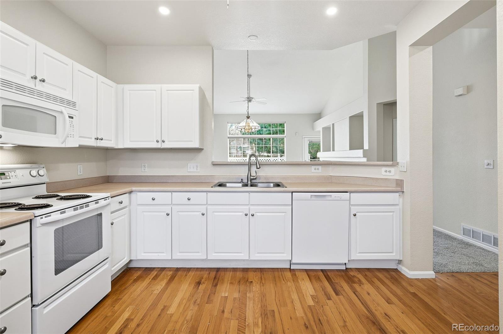 2526 South Tucson Circle Aurora, CO 80014 - Photo 16 of 33 a kitchen with granite countertop white cabinets stainless steel appliances and a sink
