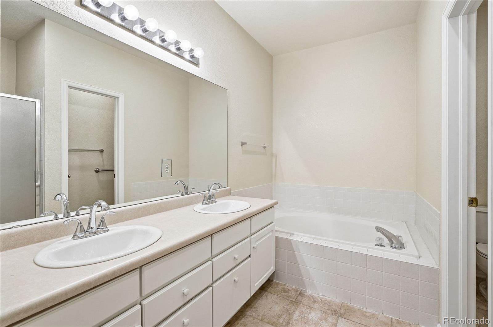 2526 South Tucson Circle Aurora, CO 80014 - Photo 24 of 33 a bathroom with a sink double vanity granite tub and a mirror