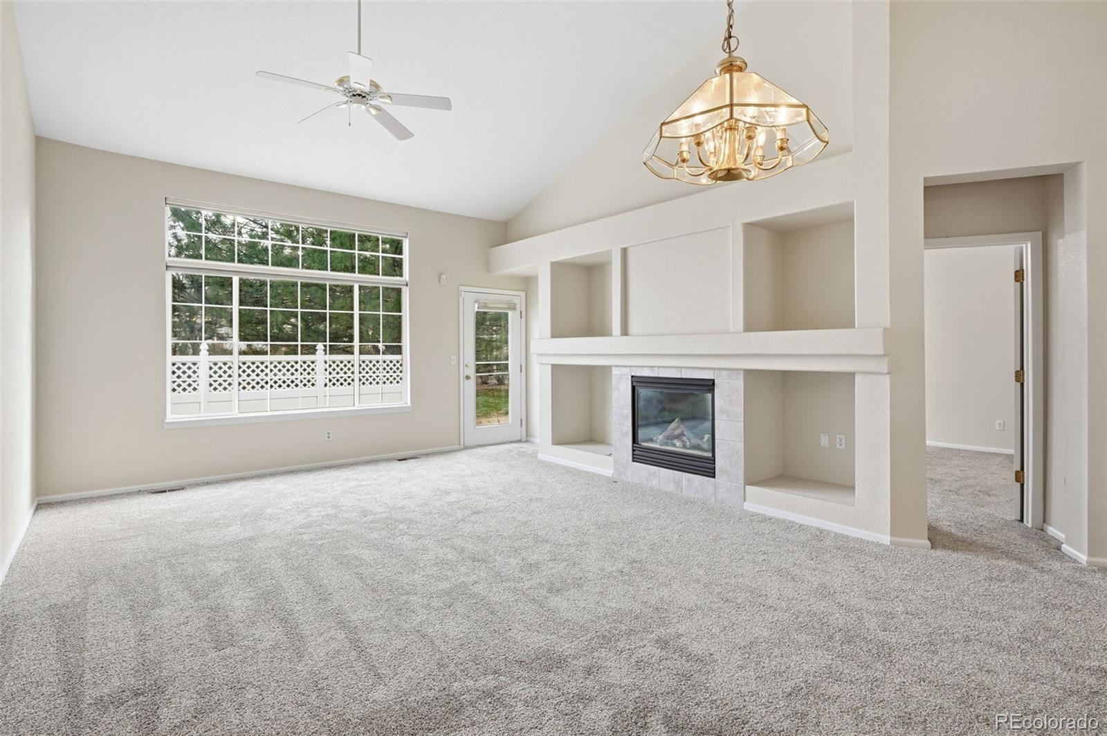 2526 South Tucson Circle Aurora, CO 80014 - Photo 10 of 33 a view of empty room with a fireplace and chandelier fan