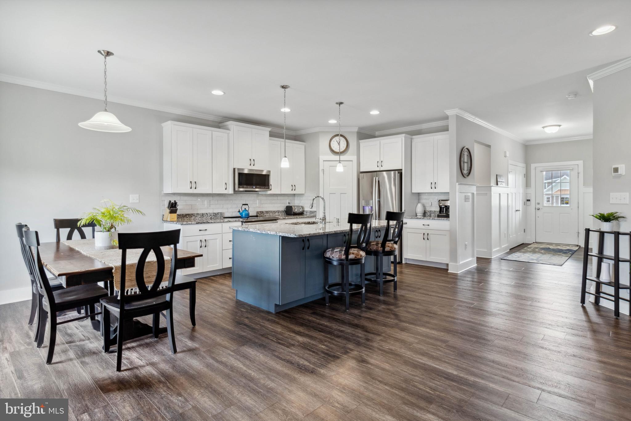 24019 Ingrams Drive Millsboro, DE 19966 - Photo 13 of 49 a kitchen with stainless steel appliances kitchen island granite countertop a table chairs and a refrigerator