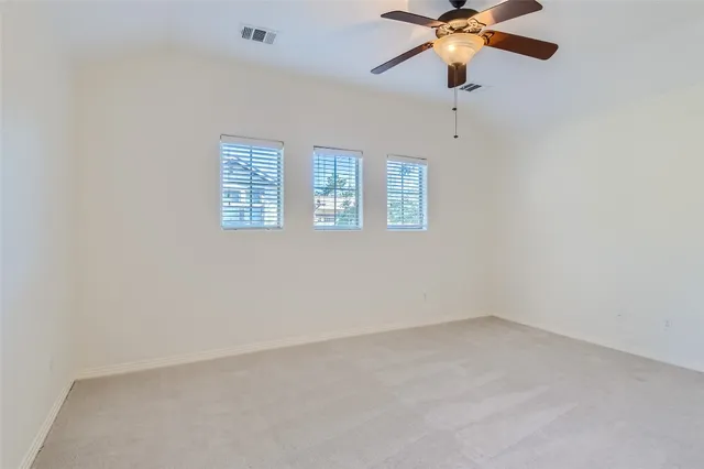 an empty room with a window and a fan