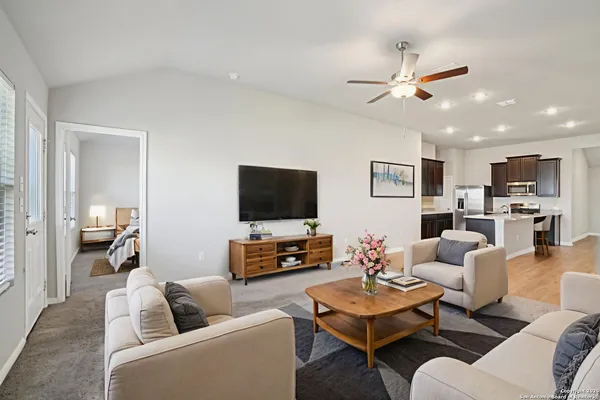 a living room with furniture kitchen view and a flat screen tv