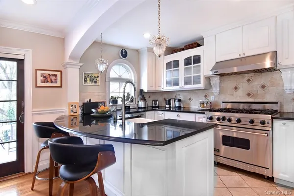 a kitchen with sink a stove and chairs