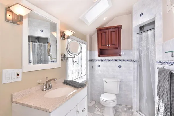 a bathroom with a sink a toilet and a mirror