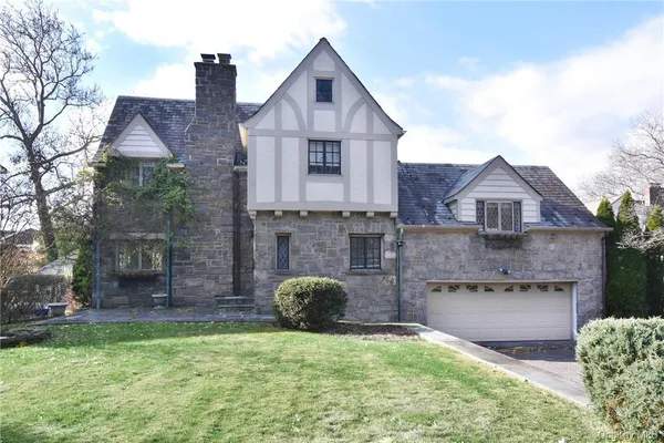 a front view of a house with a garden and yard