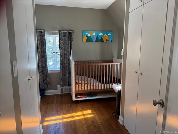 a view of a room with wooden floor and mirror