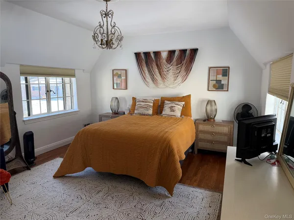 a bedroom with a bed a dresser and painting on the wall