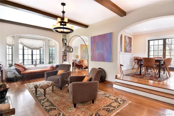 a living room with furniture a chandelier and a rug