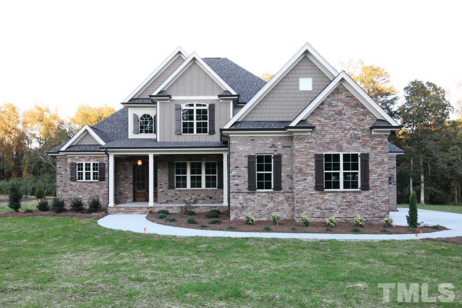 a front view of a house with a yard and trees